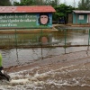 ein Moped fährt über eine überflutete Straße in einem kubanischen Dorf